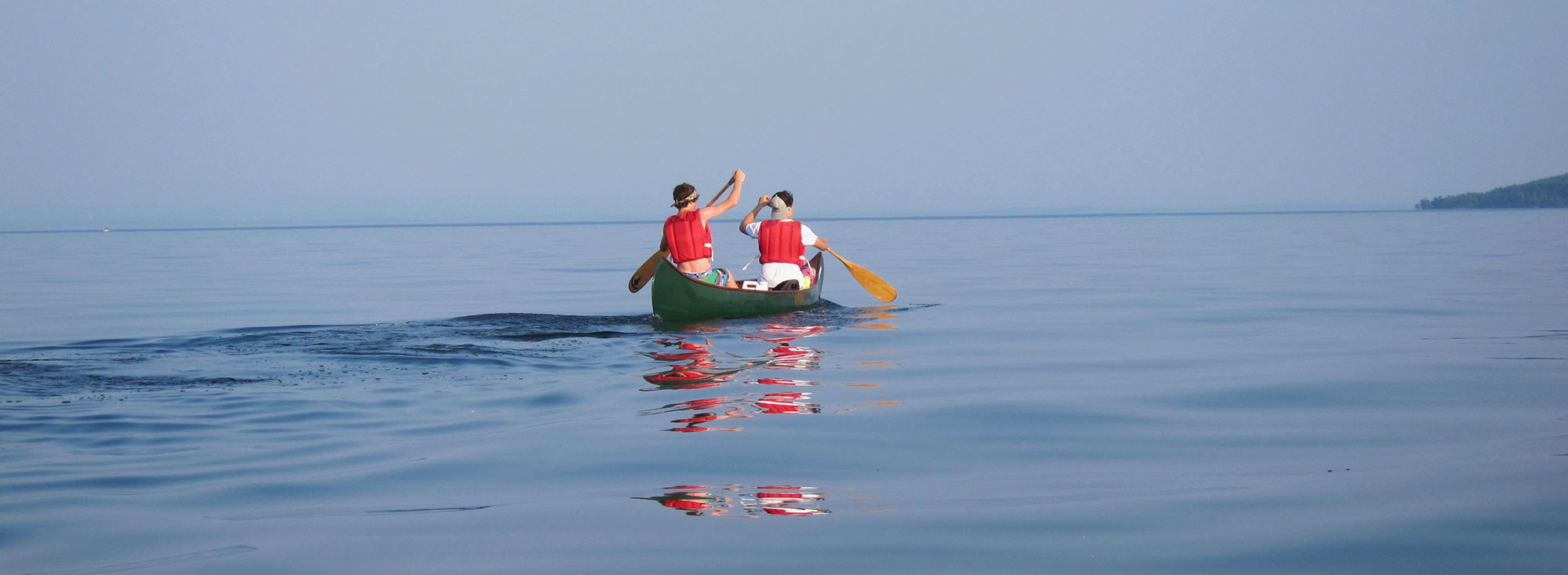 Boys in Canoe Paddling in Middle of Lake