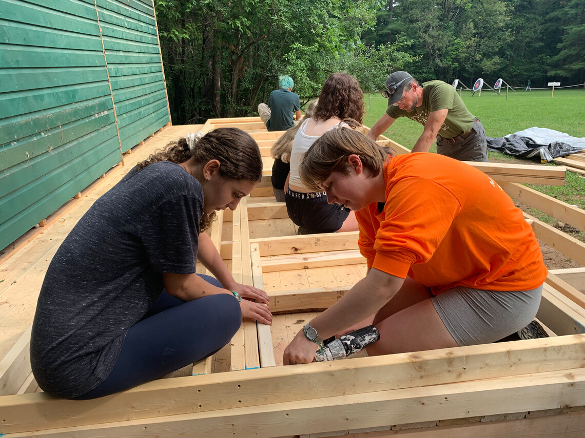 campers helping to build an addition on a building