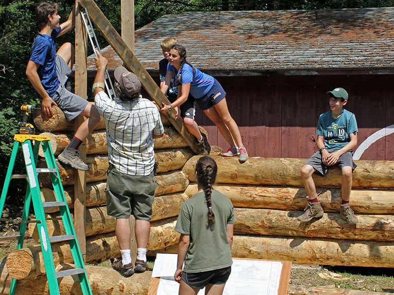 campers and instructor working on log building