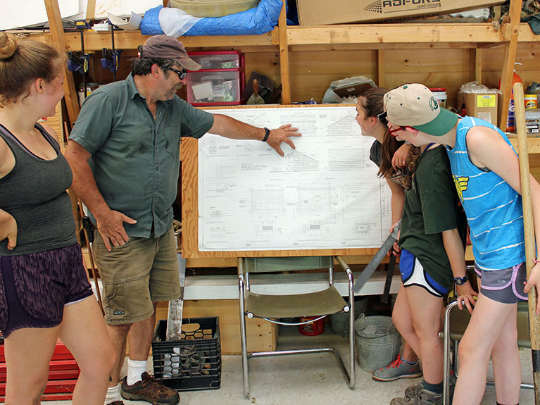 campers and instructor looking at blueprint