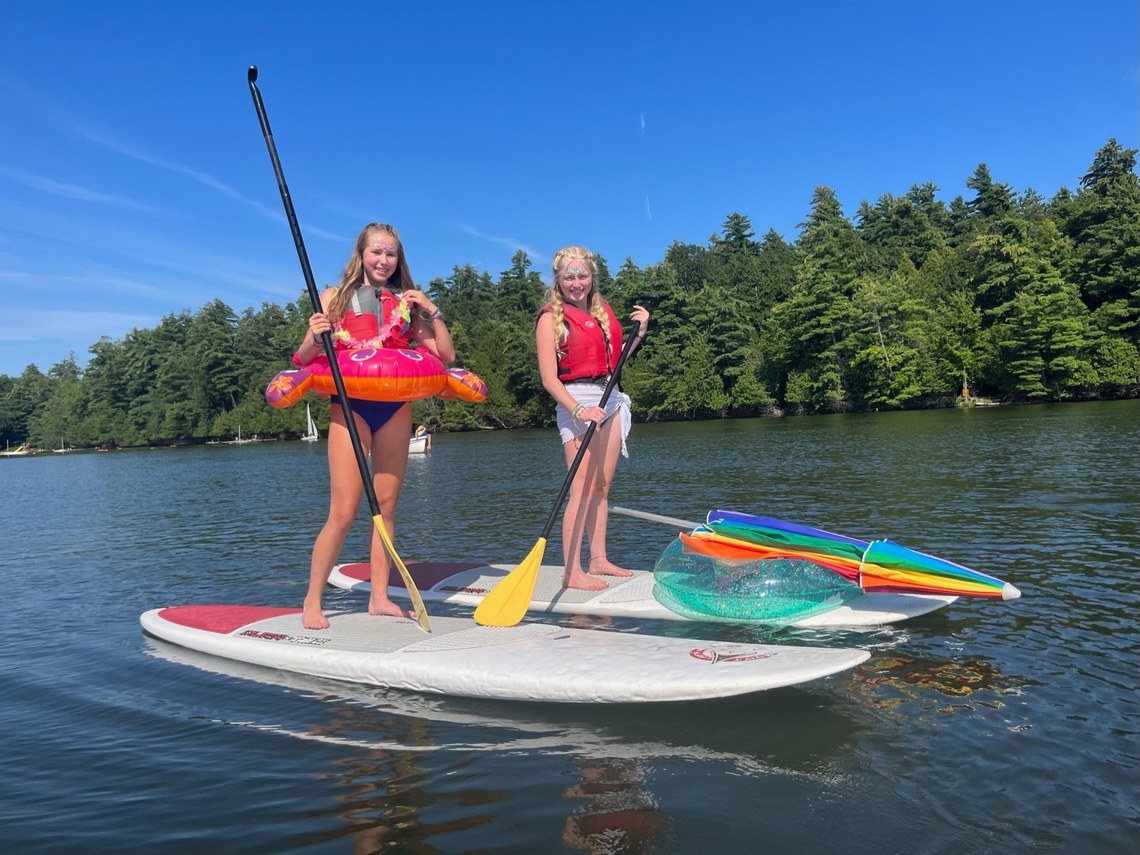 Two Campers dressed in costume standing on paddle boards
