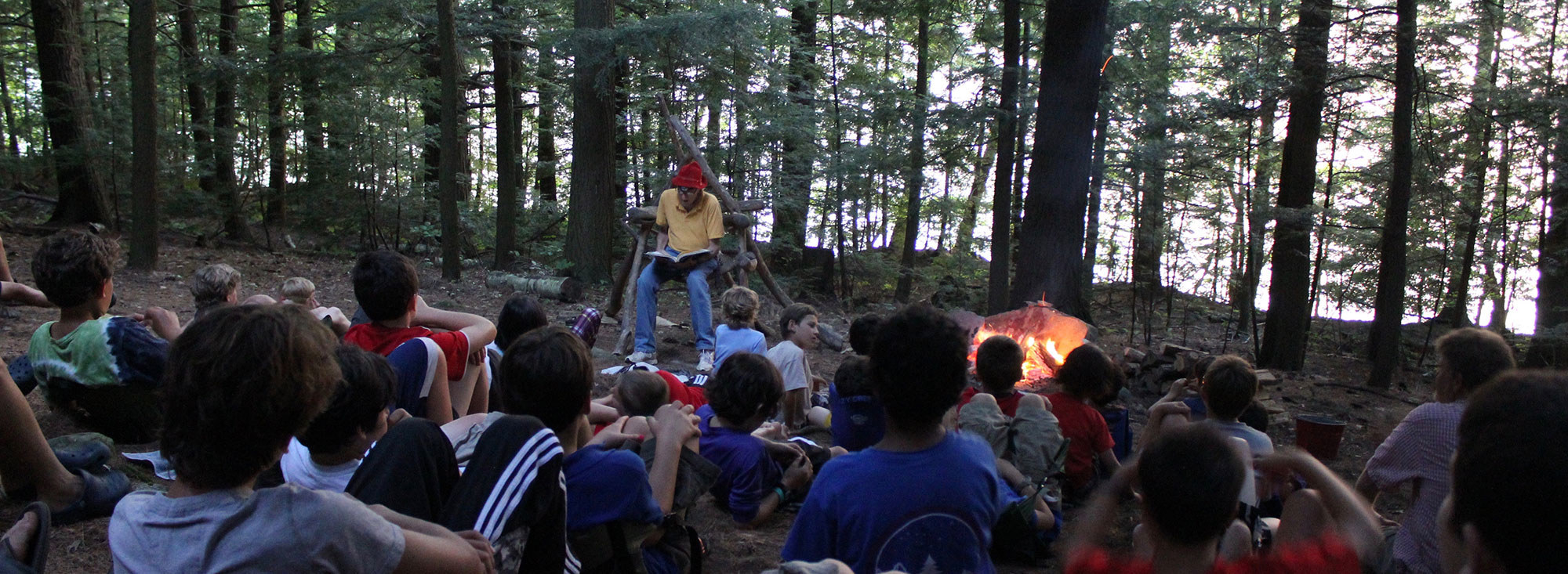 NCC Counselor talking to group of campers in the evening