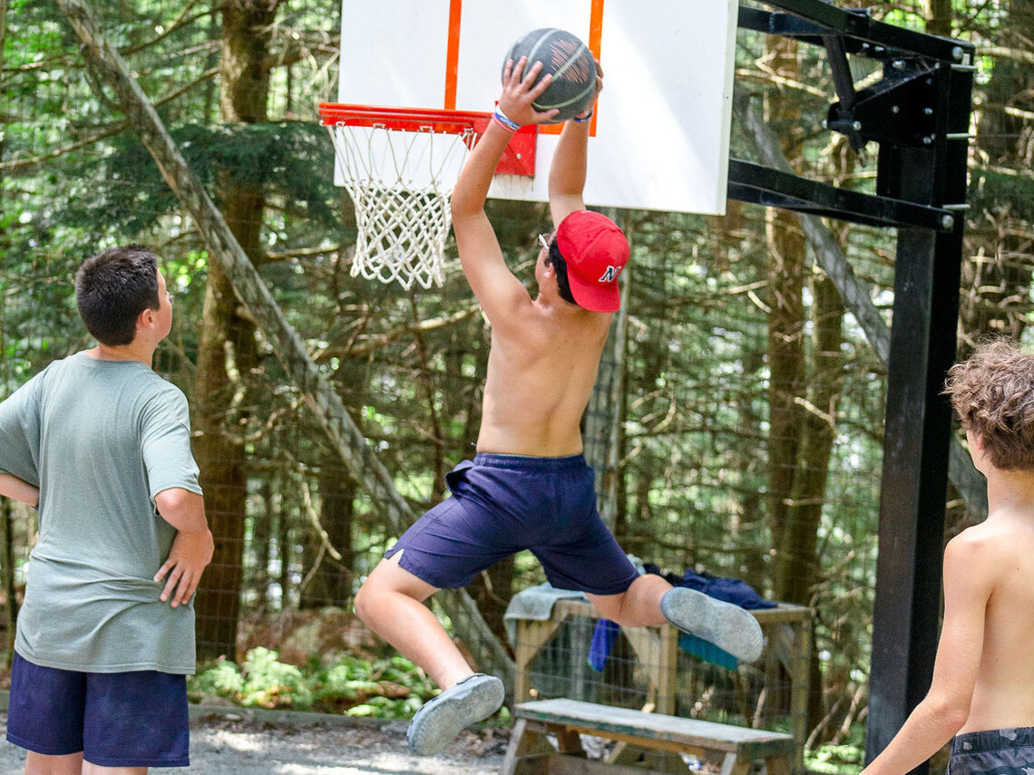 boy jumping up to dunk a basketball