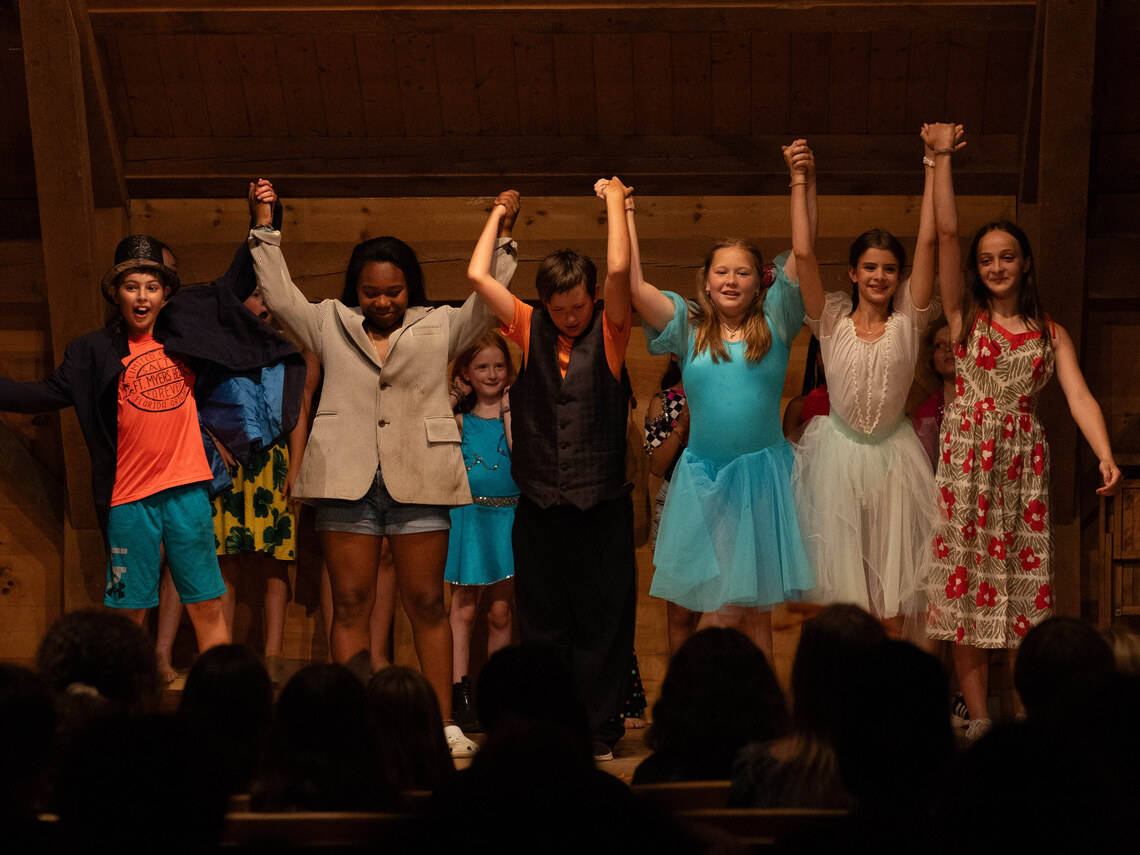 a group of campers taking a bow on stage