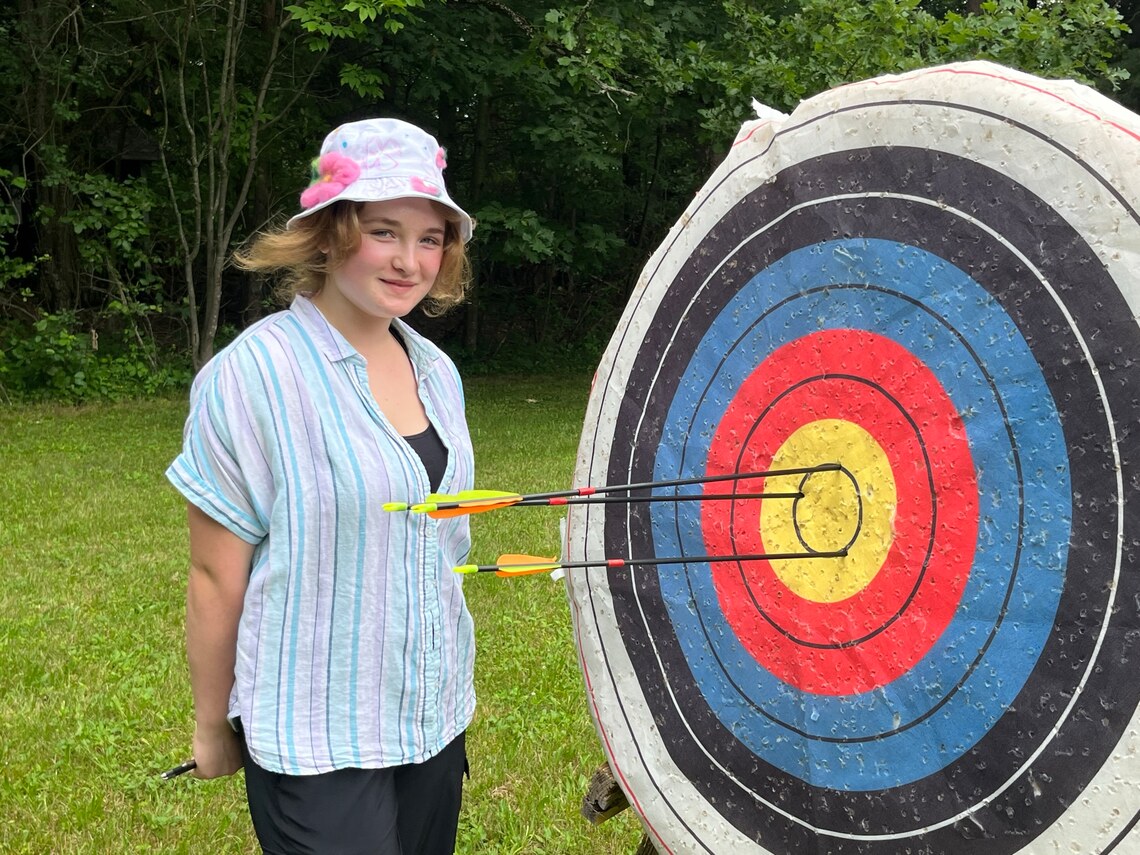 Girl standing next to archery target