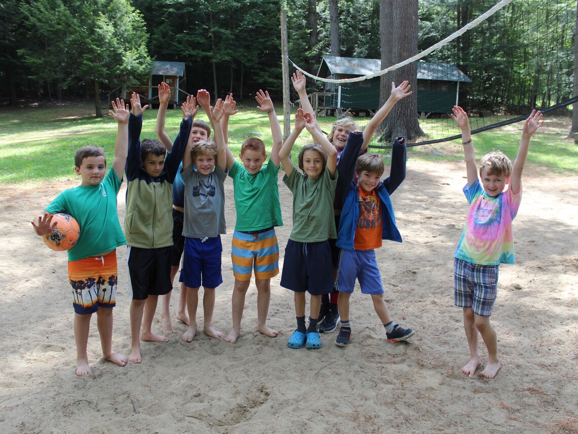 a group of campers smiling on a volley ball court