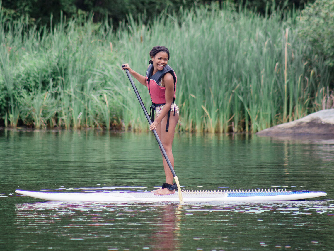 a camper smiling on a paddleboard