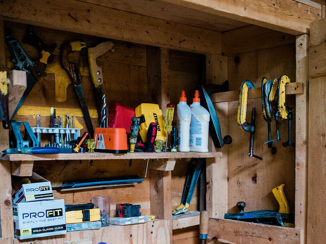 the inside of a woodshop cupboard full of various tools