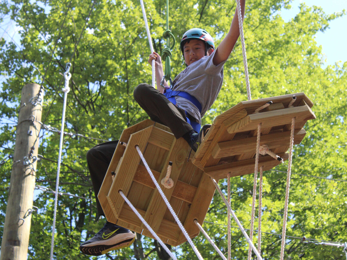 a camper having fun while in the ropes course