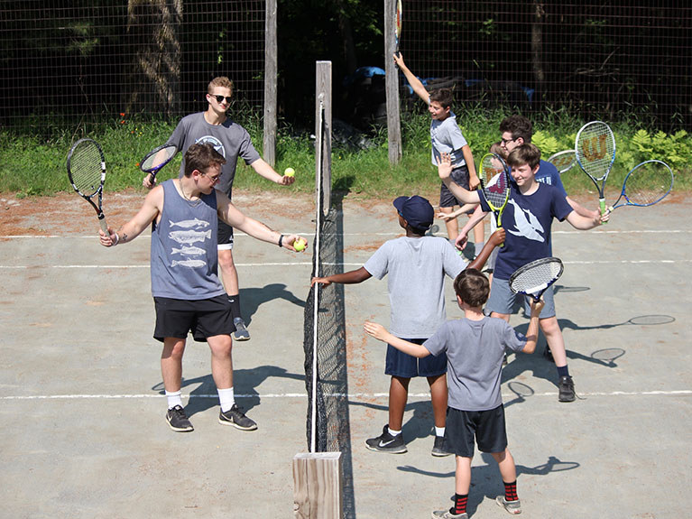 boys and instructors on tennis court