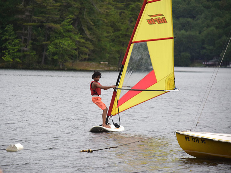 camper windsurfing on lake