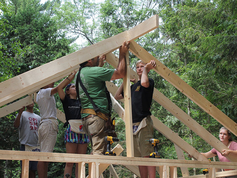 campers and instructor building timber frame