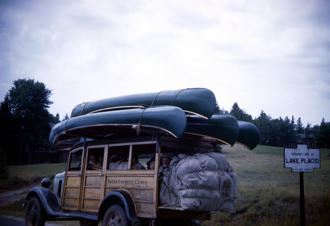 Carload of campers with a roof topped with canoes on their way to a camping trip near Lake Placid, NY