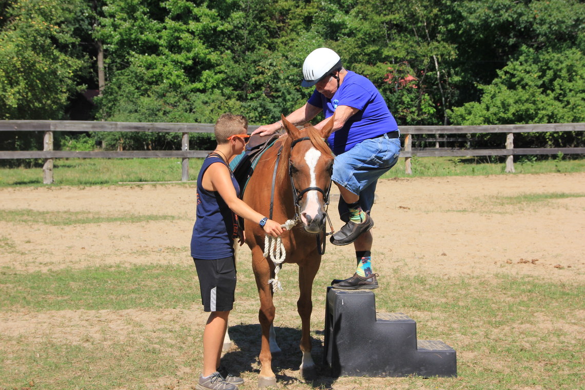 Former Camper and staff preparing to go horseback riding during Alumni Reunion