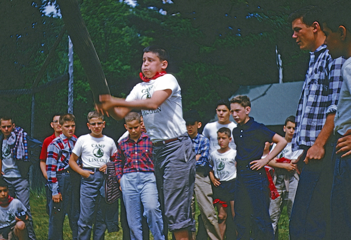 A boy holding his breath as he tosses a log as part of a competition