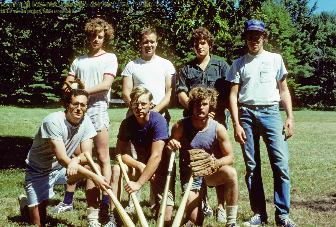 A group of men posing with their baseball mitts and bats