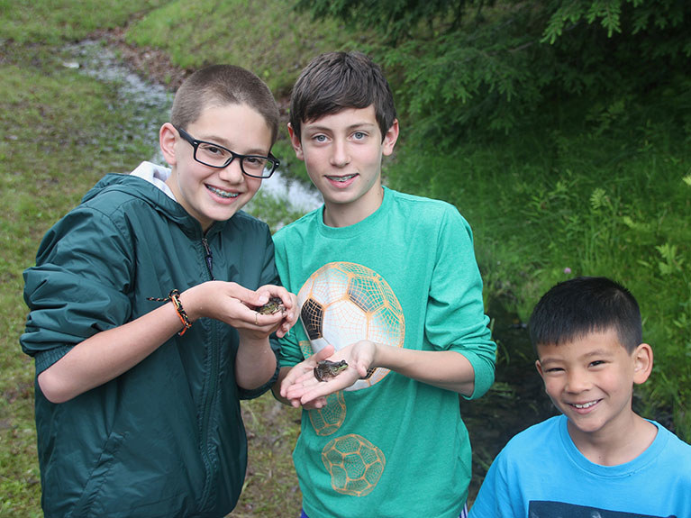 Boys near stream with frogs they caught